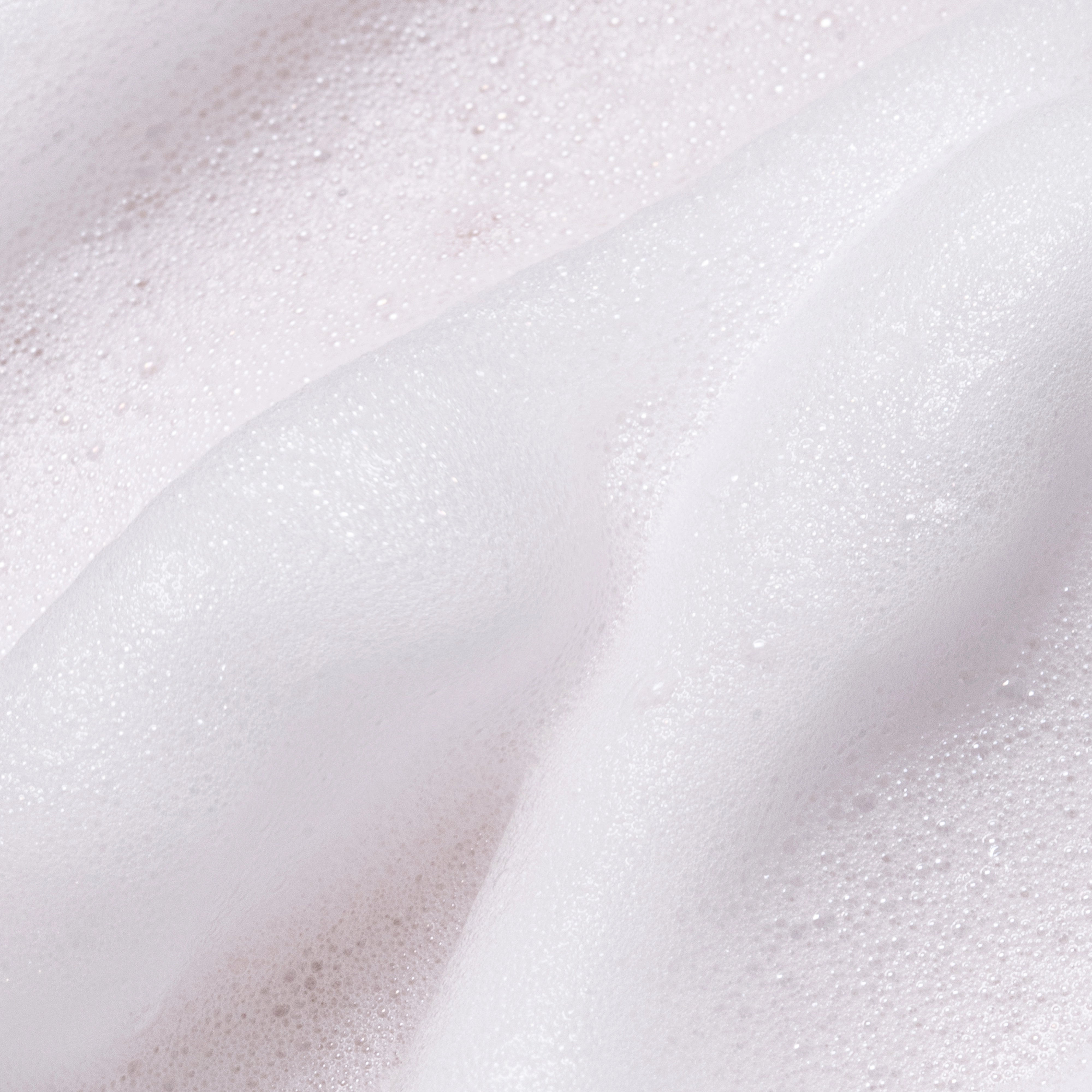 Close-up of Feel Confident Thickening Foam texture — lightweight non-greasy formula for natural hair volume